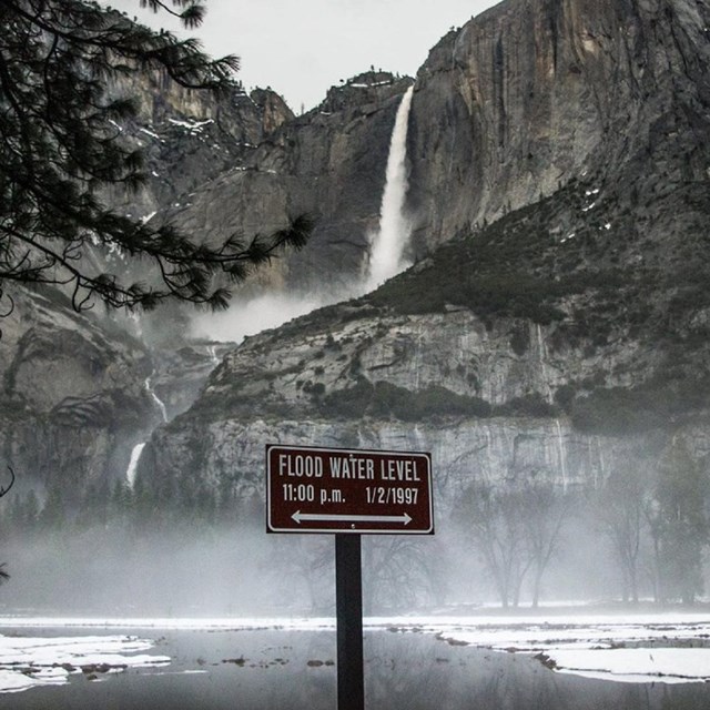 Flood Water Level sign in front of waterfall